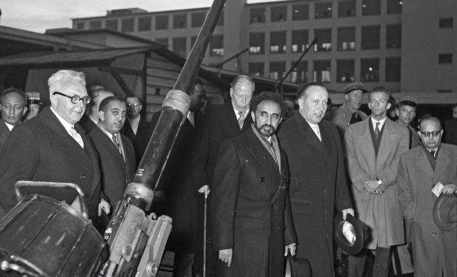 Emil Georg Bührle (di spalle, con bastone da passeggio) mostra all'imperatore etiope Hailé Selassié (al centro) i suoi cannoni nel novembre 1954 (Björn Erik Lindros, ETH-Bildarchiv).