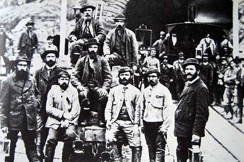 Bauarbeiter um 1880 vor dem Südportal des Gotthardtunnels in Airolo. Quelle: https://de.wikipedia.org/wiki/Gotthardtunnel