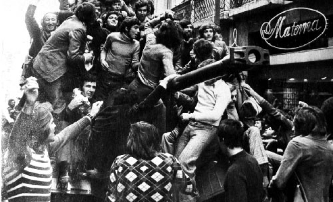 Portuguese people climb a tank during the Carnation Revolution.